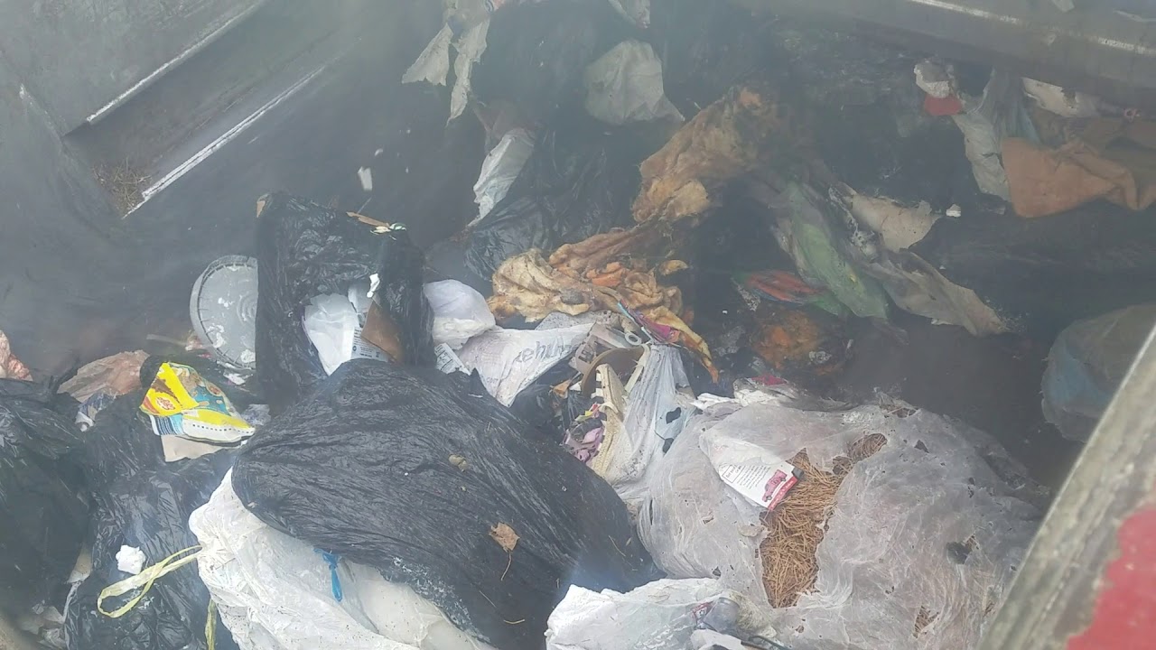 Dumping rear loader garbage truck at transfer station