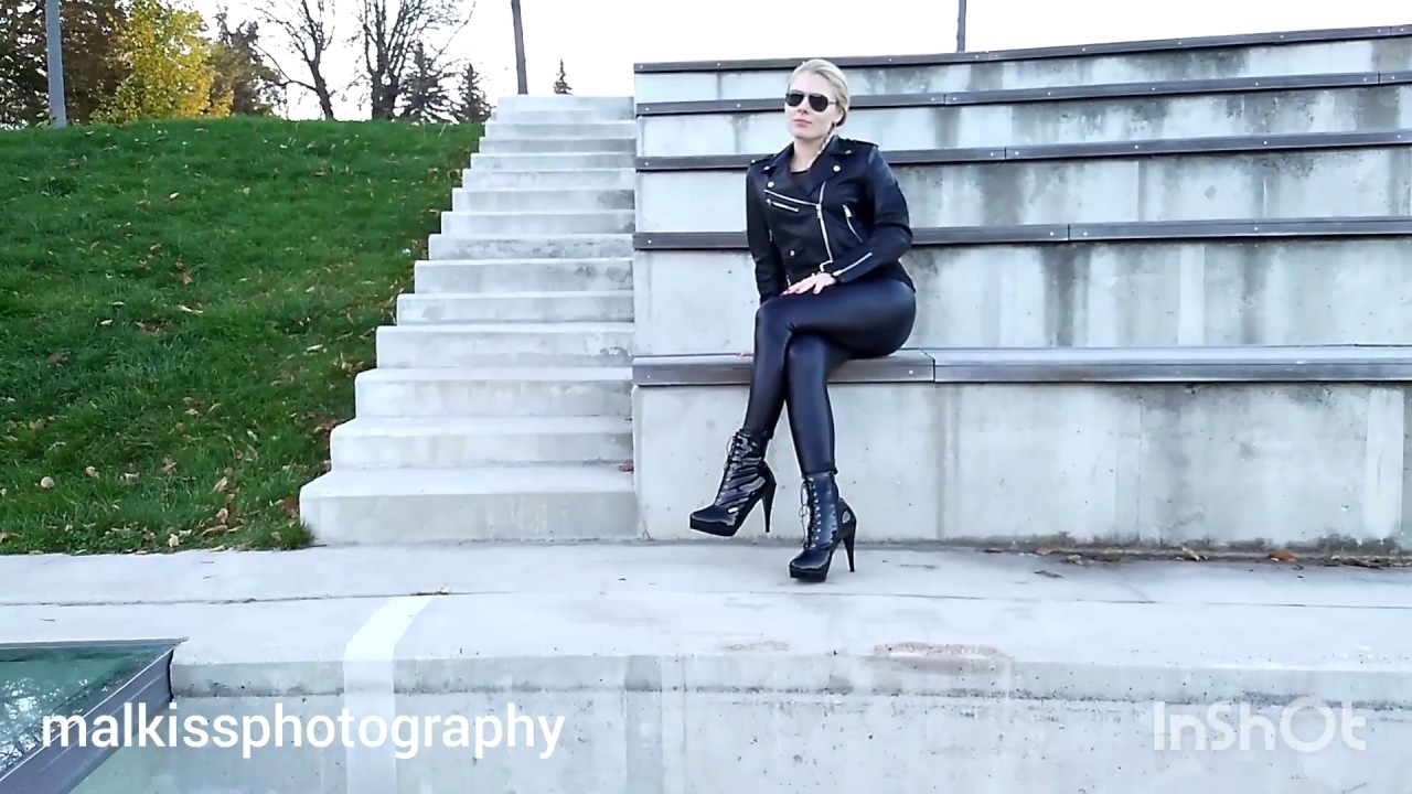 Caribig in black shiny wetlook tight leggings, leather motorcycle jacket and vinyl lace ankle boots