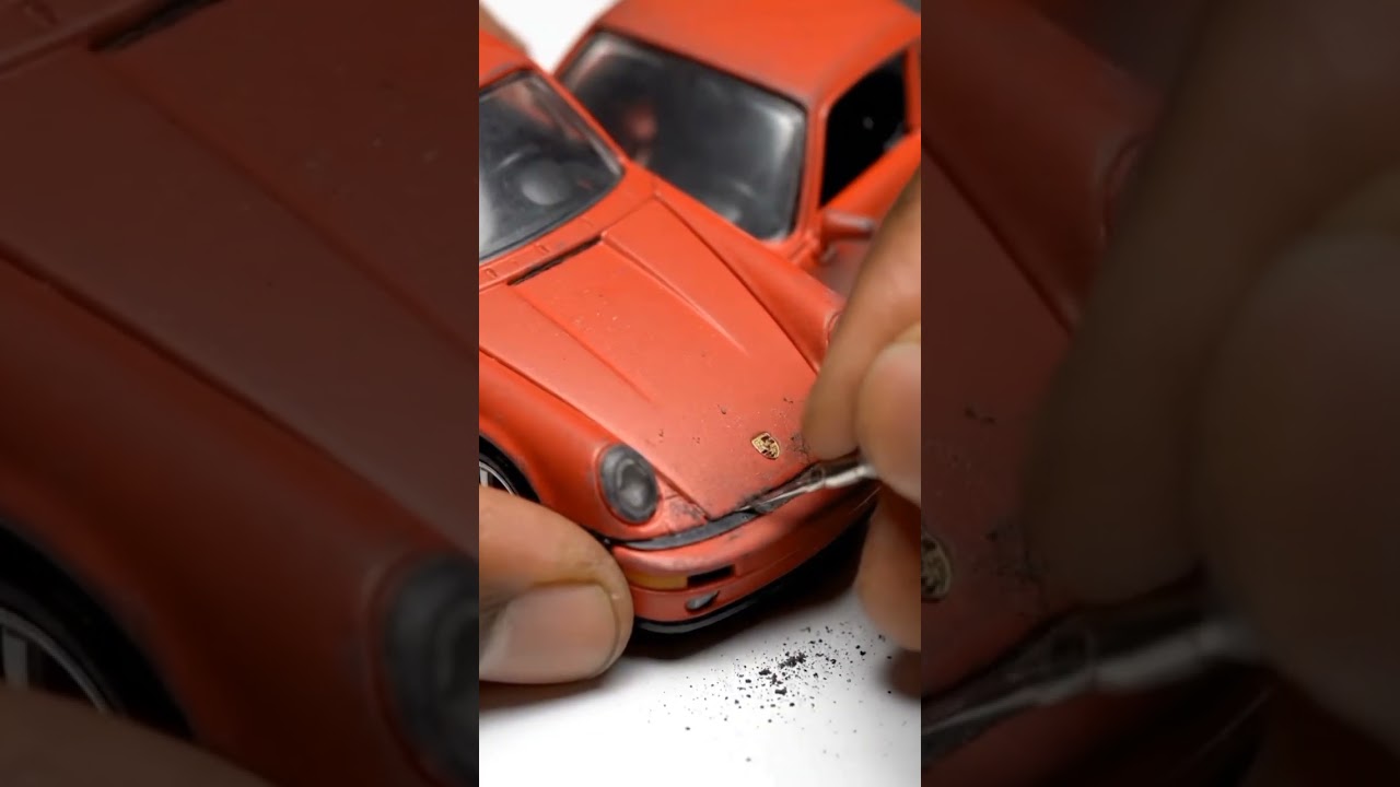 Dull red Hot Wheels Porsche restored into a sleek glossy black finish on a clean white table HQ