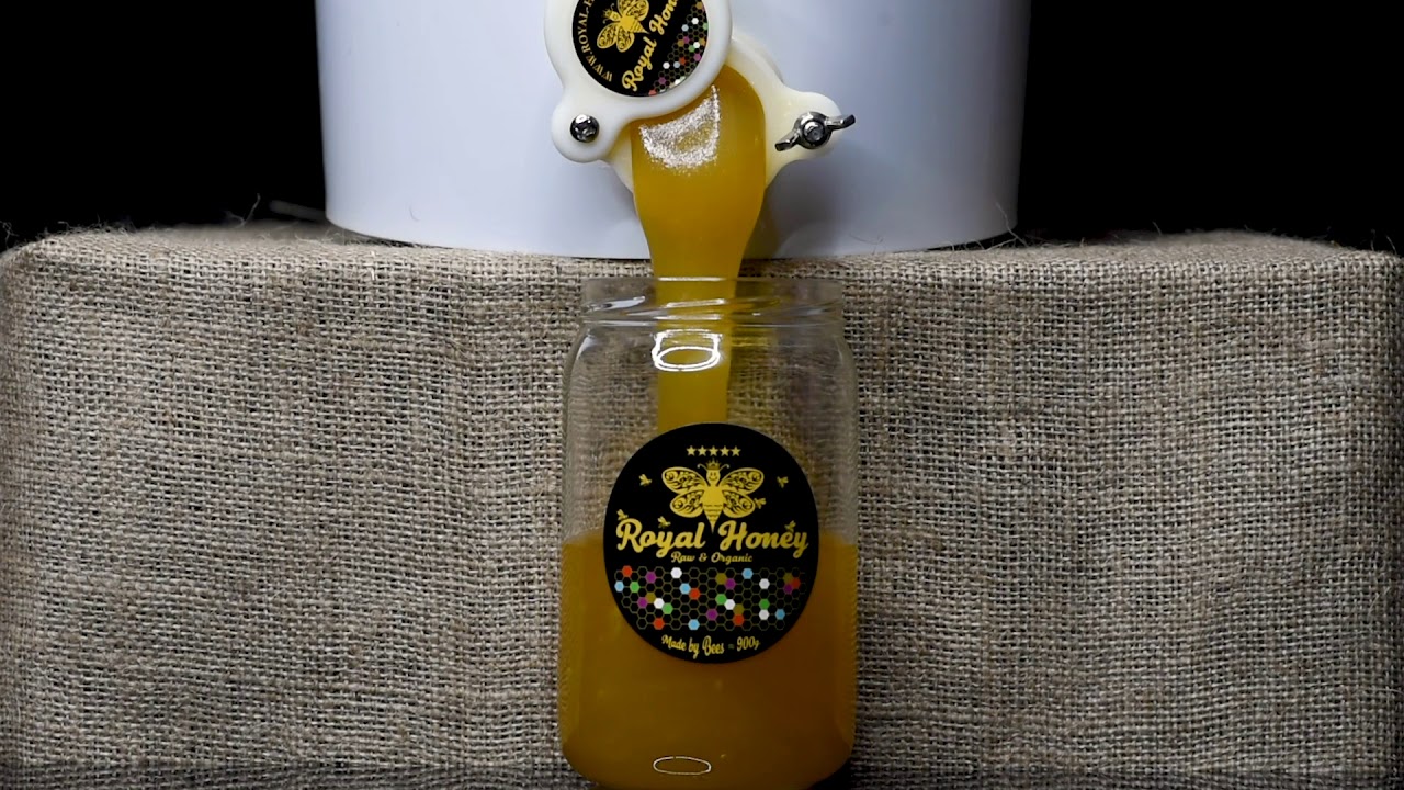 Natural honey filling into a jar