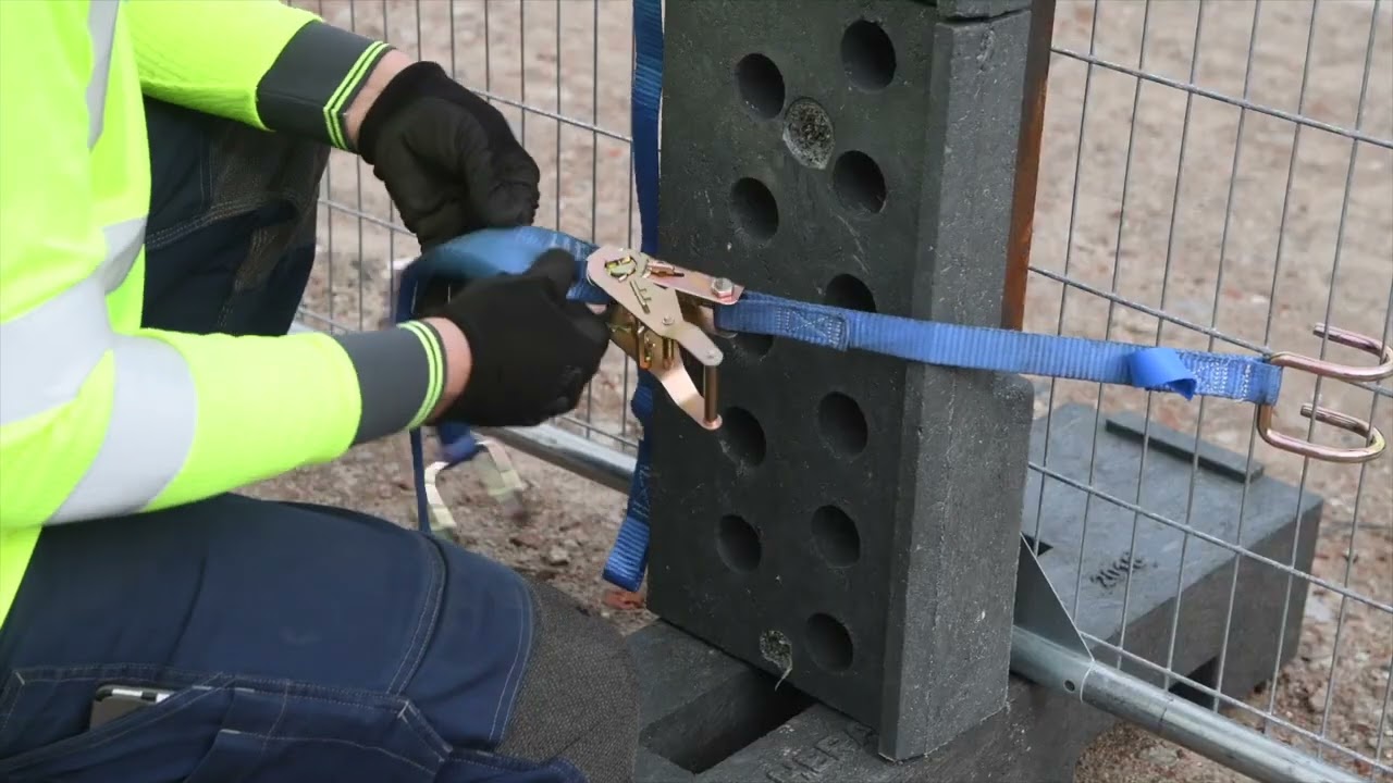 Fixation du rack de transport et de la sangle d'arrimage à une clôture de chantier