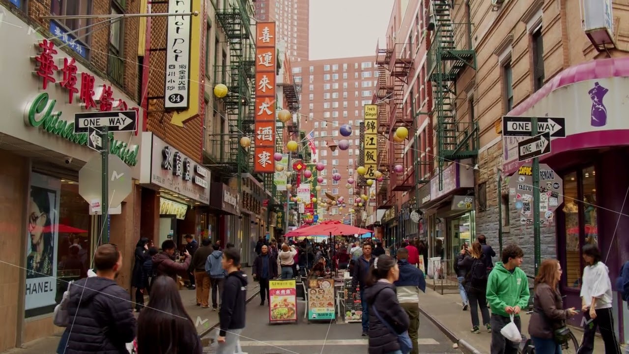 Crowded Doyers Street in Chinatown, Manhattan, New York City, full of tourists walking and shopping