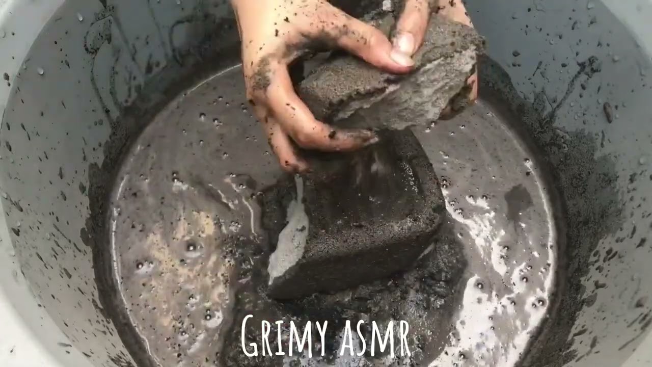 Dusty Charcoal Sand Crumbling in Water 