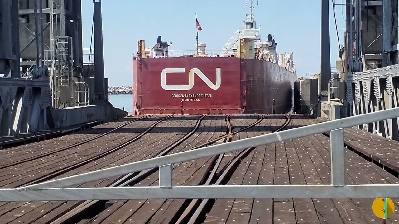 Train ferry boat docks backwards at the wharf of Matane
