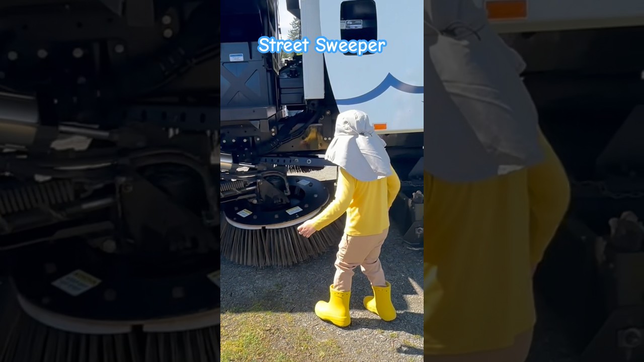 Little Boy Inspecting a Large Street Sweeper Truck