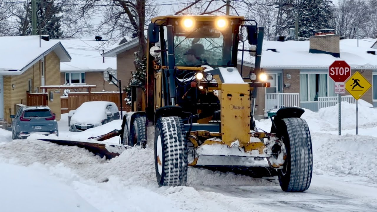 Snow Removal John Deere Grader Plowing after Major Snow Storm.