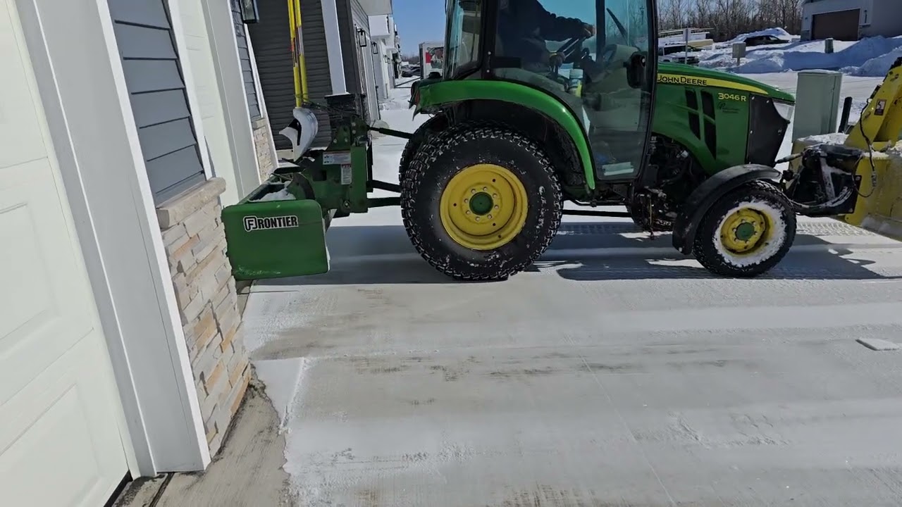 Cleaning a residential driveway with a John Deere 3046R tractor 🚜