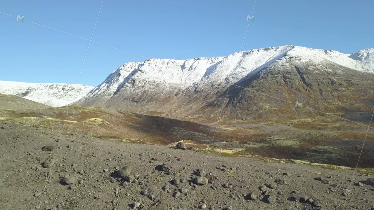 Landscape with mountains covered by snow under cloudy sky in Iceland