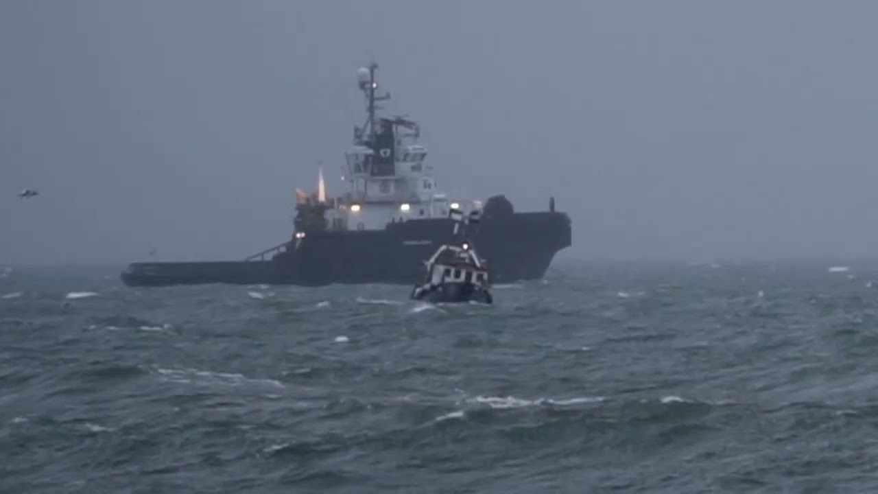 Tug battles heavy barge at anchor off Newlyn