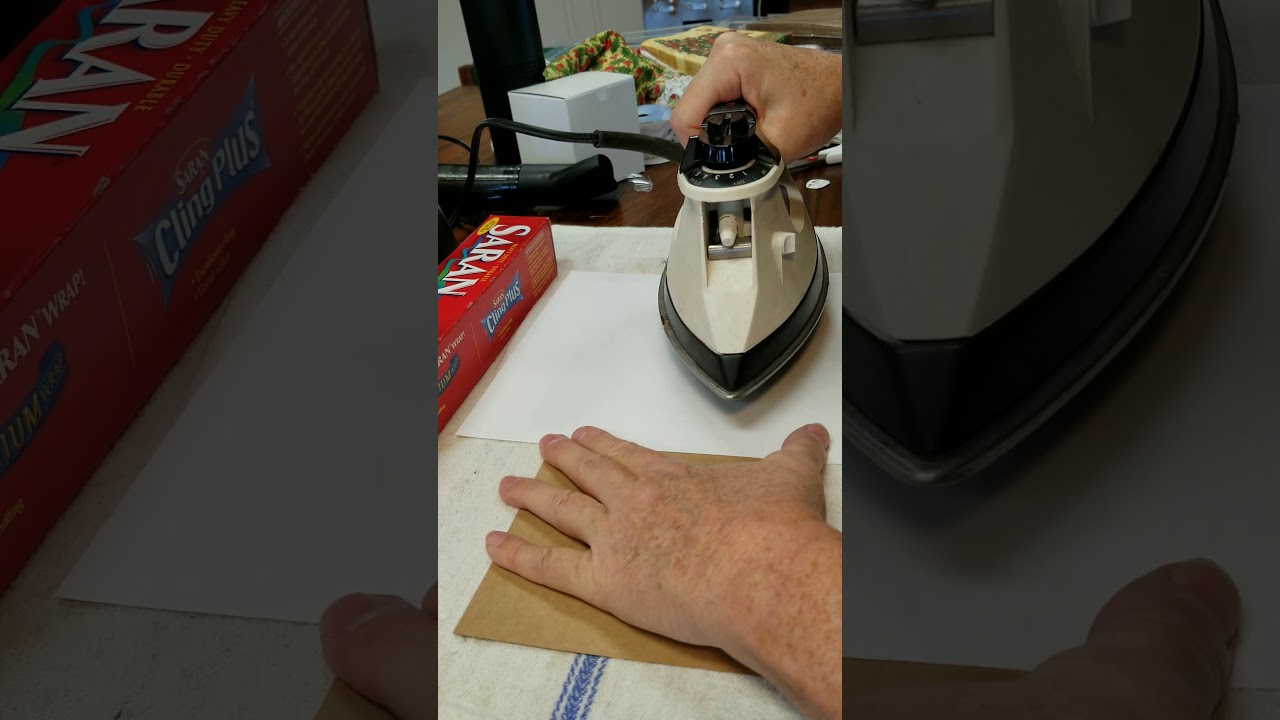 Applying a paper napkin to a card with cling wrap
