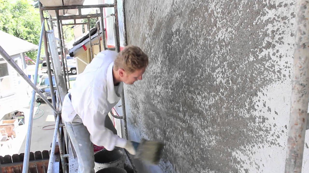Stucco dash finishes by hand using a dash brush.