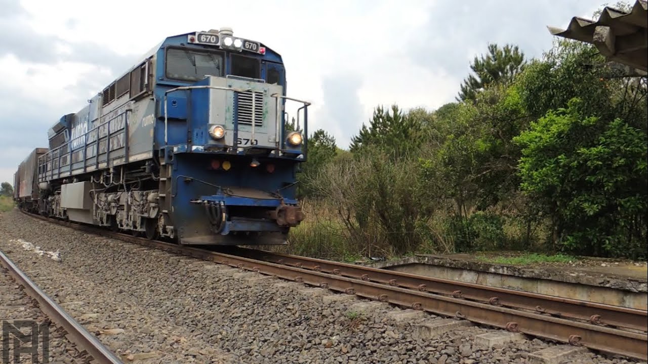 Trem carregado passando próximo a estação abandonada