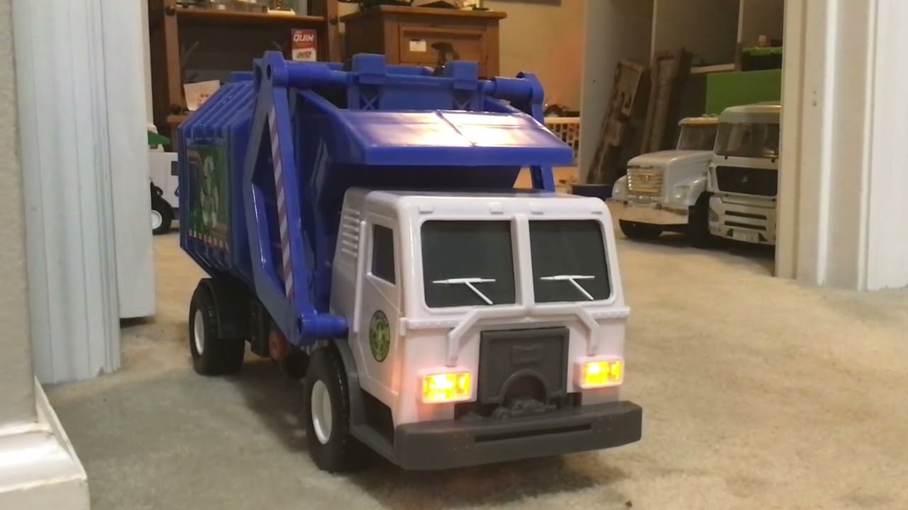 Playing with toy garbage trucks.