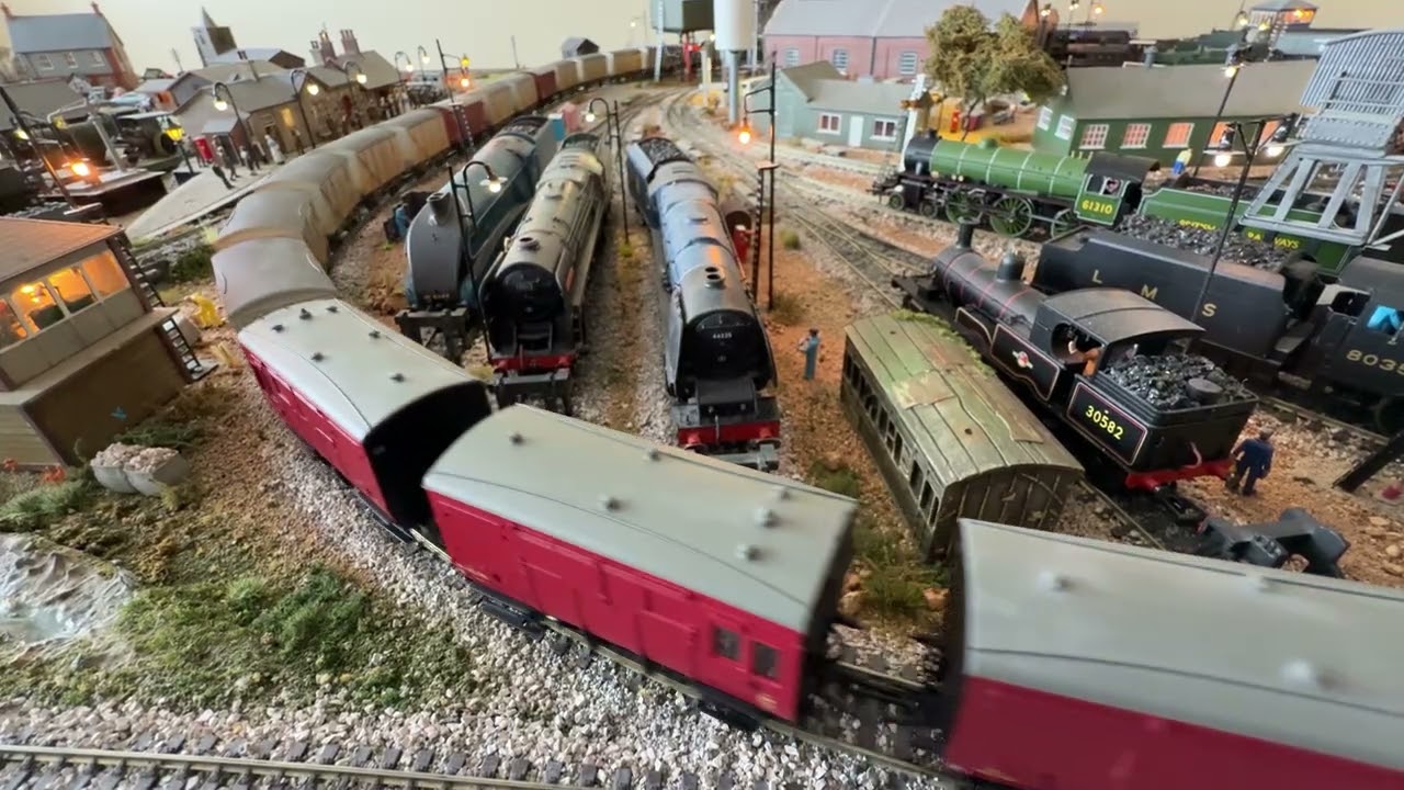 Steam engine sidings passed by a class 66 freight train.