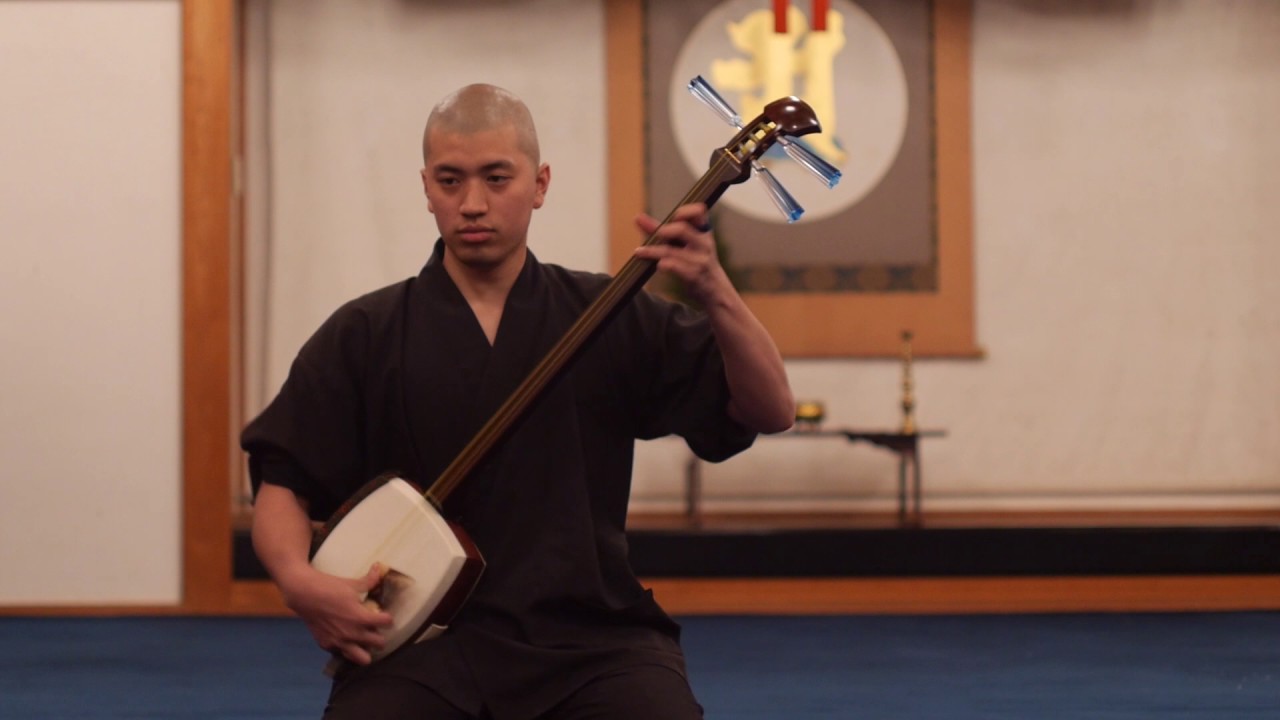 Buddhist monk playing a shamisen