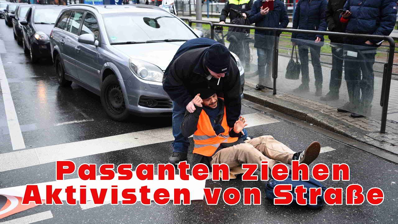 Aktivisten kleben sich auf Fahrbahn - Passanten ziehen zwei davon von der Straße