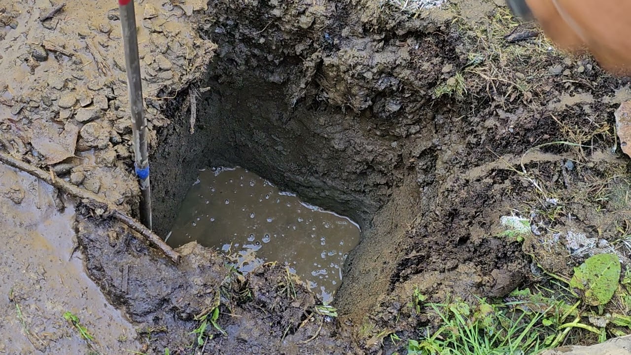 Using pressure washer to dig a fence post hole.