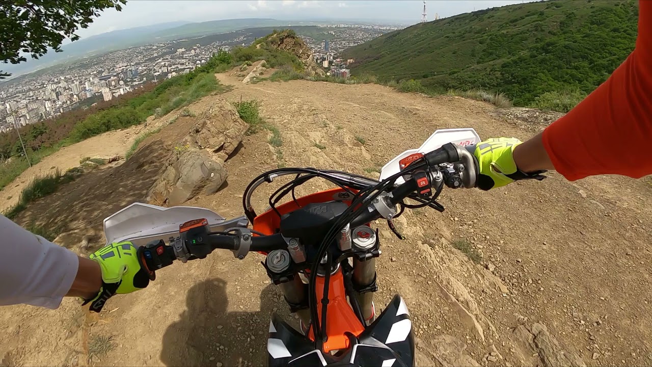 KTM Freeride 250F on mountain ridge above lake.