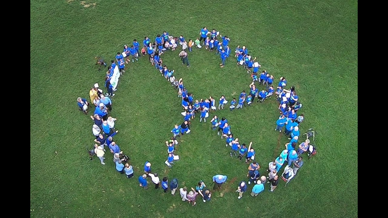 Human Peace symbol formed by kids roughly from 1 to 92