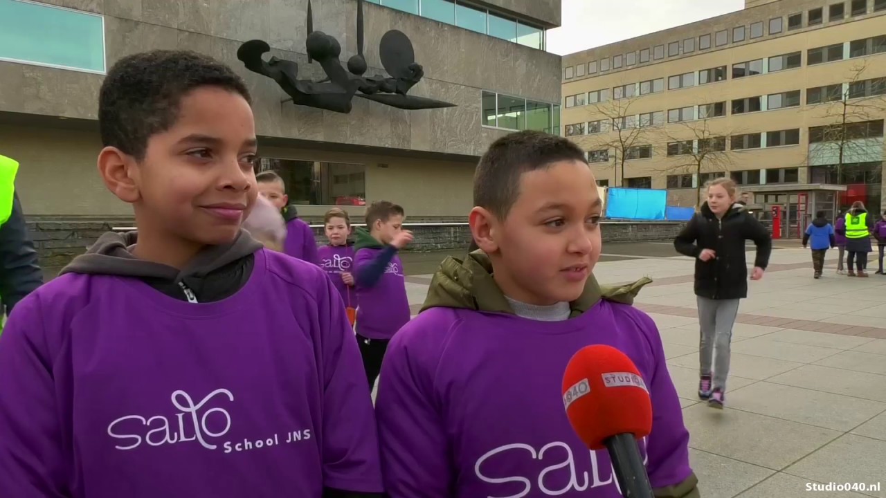 Kinderen en leerkrachten delen koekjes uit: 