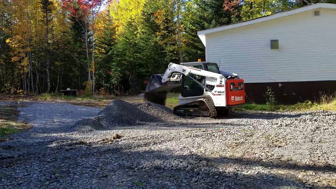 Spreading stone up the cabin with the Bobcat T450