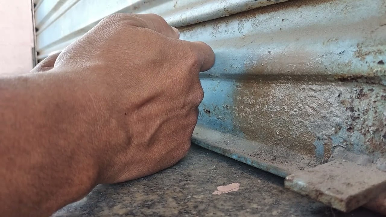 tirando pedaço da chave da fechadura porta de aço loja, com refil de cola quente e um isqueiro.