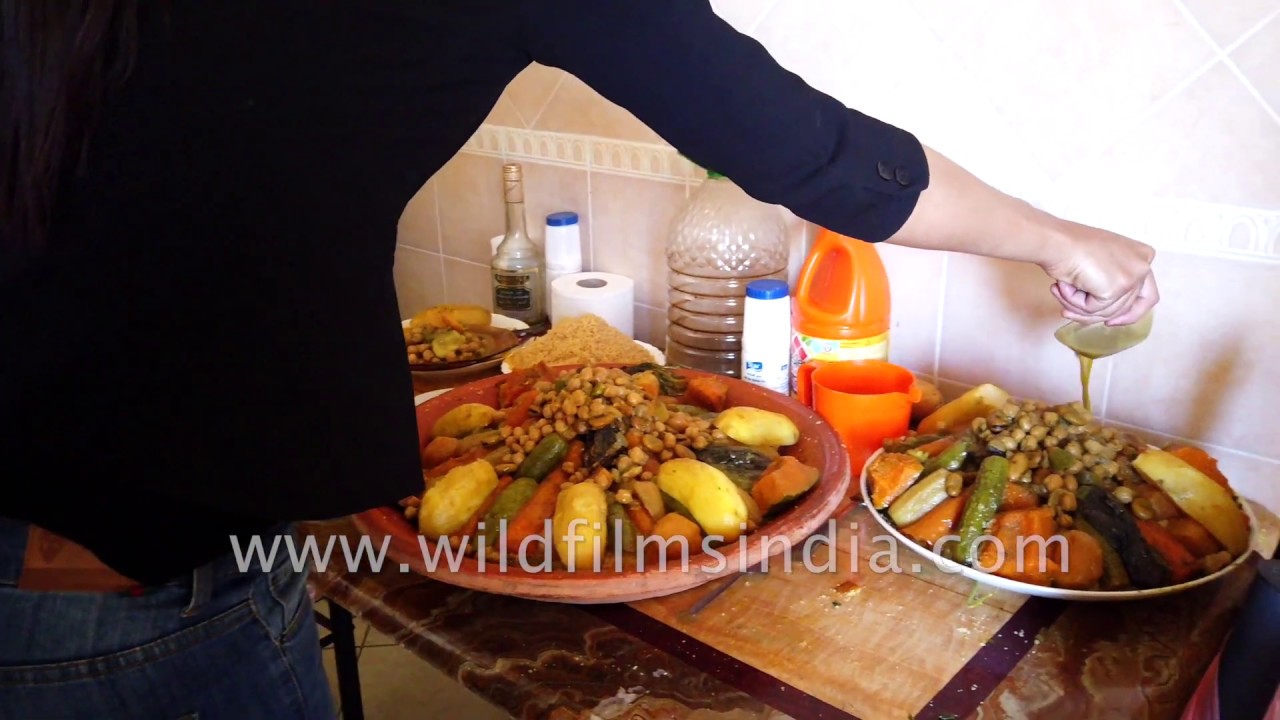 Moroccan women garnish couscous with boiled veggies