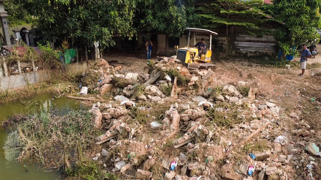 Clearing waste construction stone by skill bulldozer pushing & 5T truck transport soil Filling land