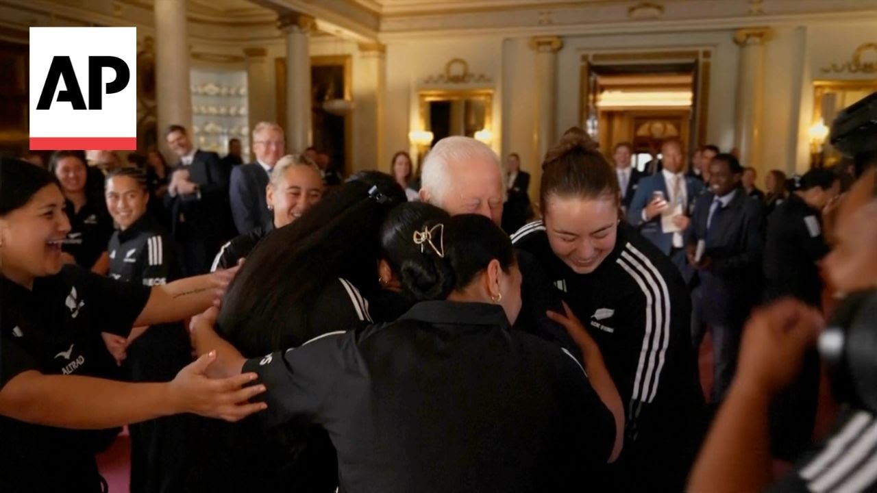 King Charles gets a group hug from the New Zealand women's rugby team