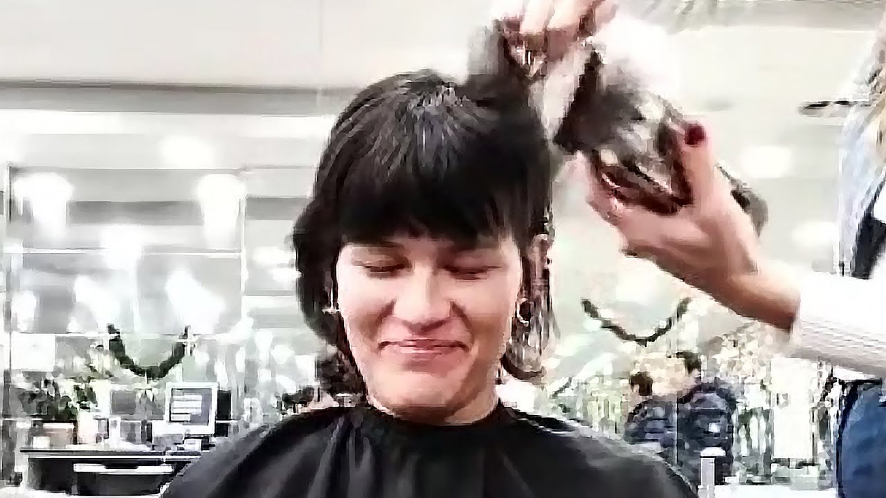 Mullet girl closes her eyes as the clippers go to work