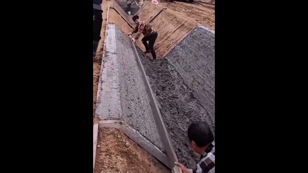 Making concrete drainage ditch with skilled construction workers