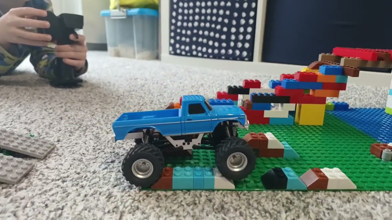 RC Monstertruck Crawler 1/36 überwindet ein Hindernisparcour aus Klemmbausteinen.