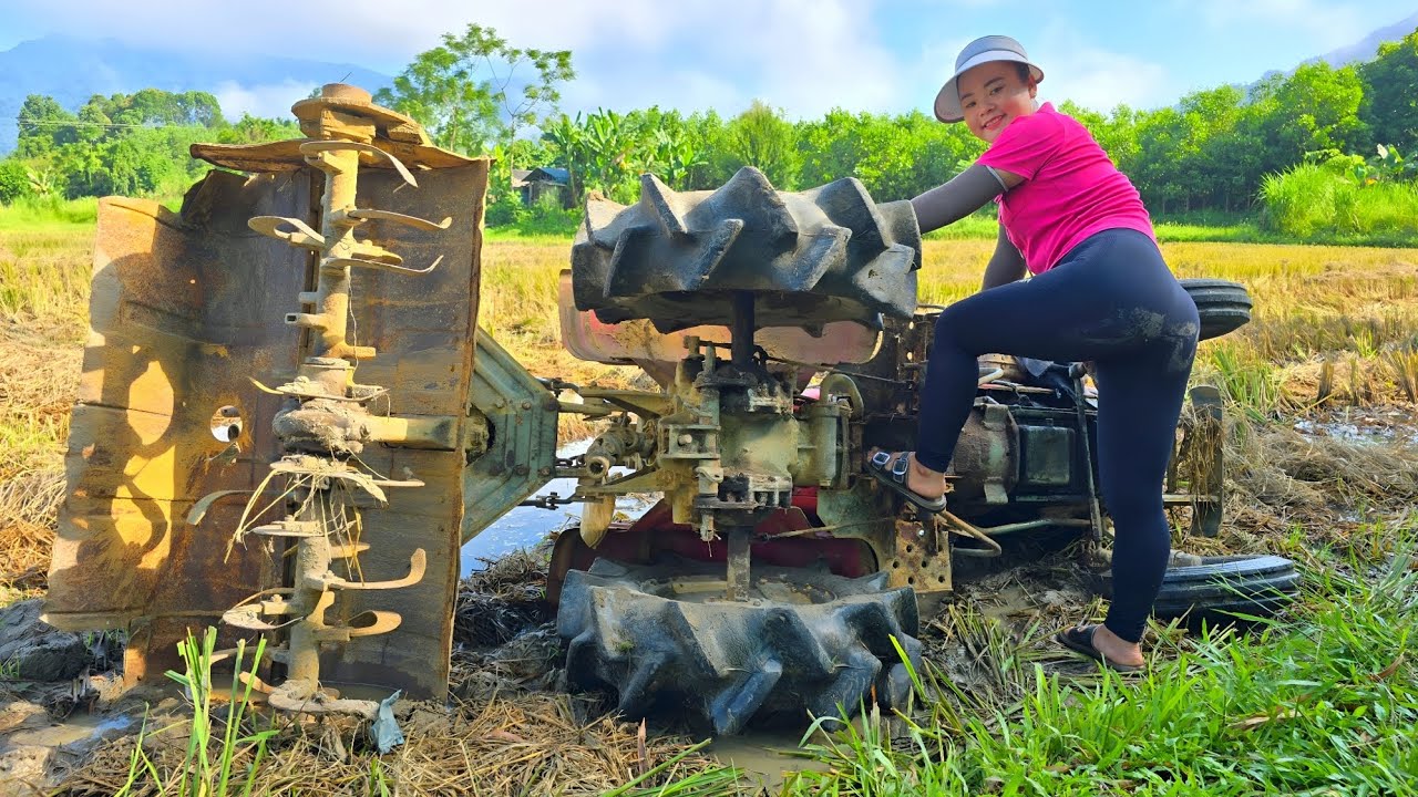 Rescue girl repairs and restores an overturned and broken tractor in the field.
