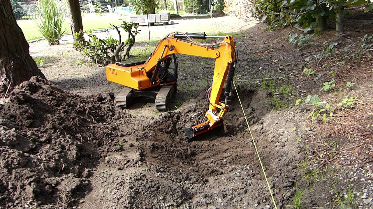 RC earth digger 4200 XL bei der Arbeit mit dem Schwenklöffel  im Garten