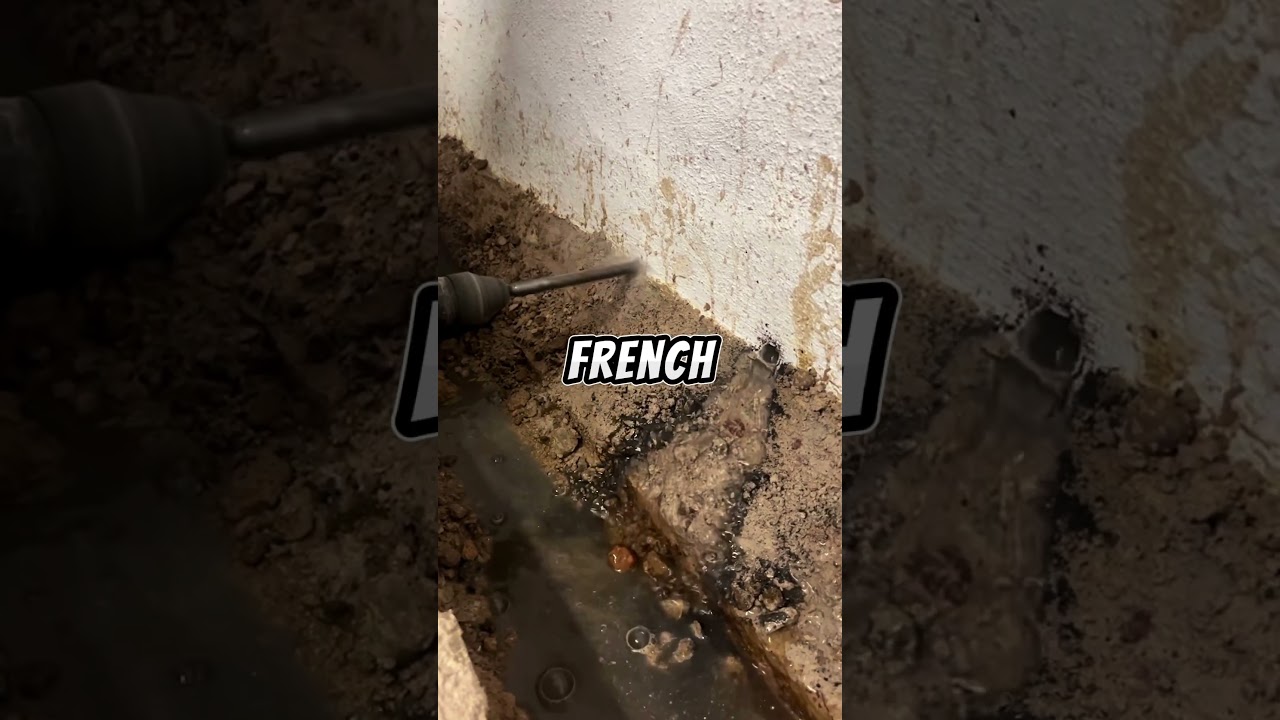 Drilling weep holes in the cinder block walls during a french drain installation. 💧