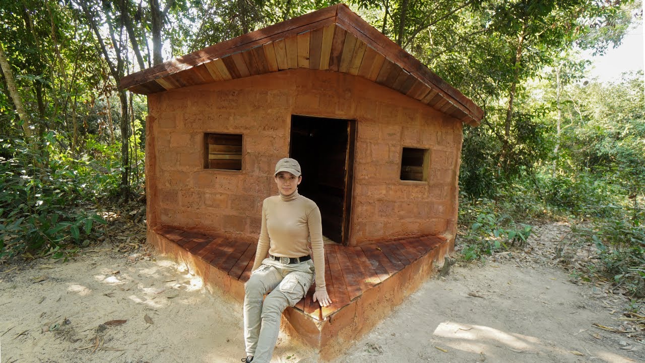 Building Complete Survival Brick Bushcraft shelter with wooden roof in Wilderness