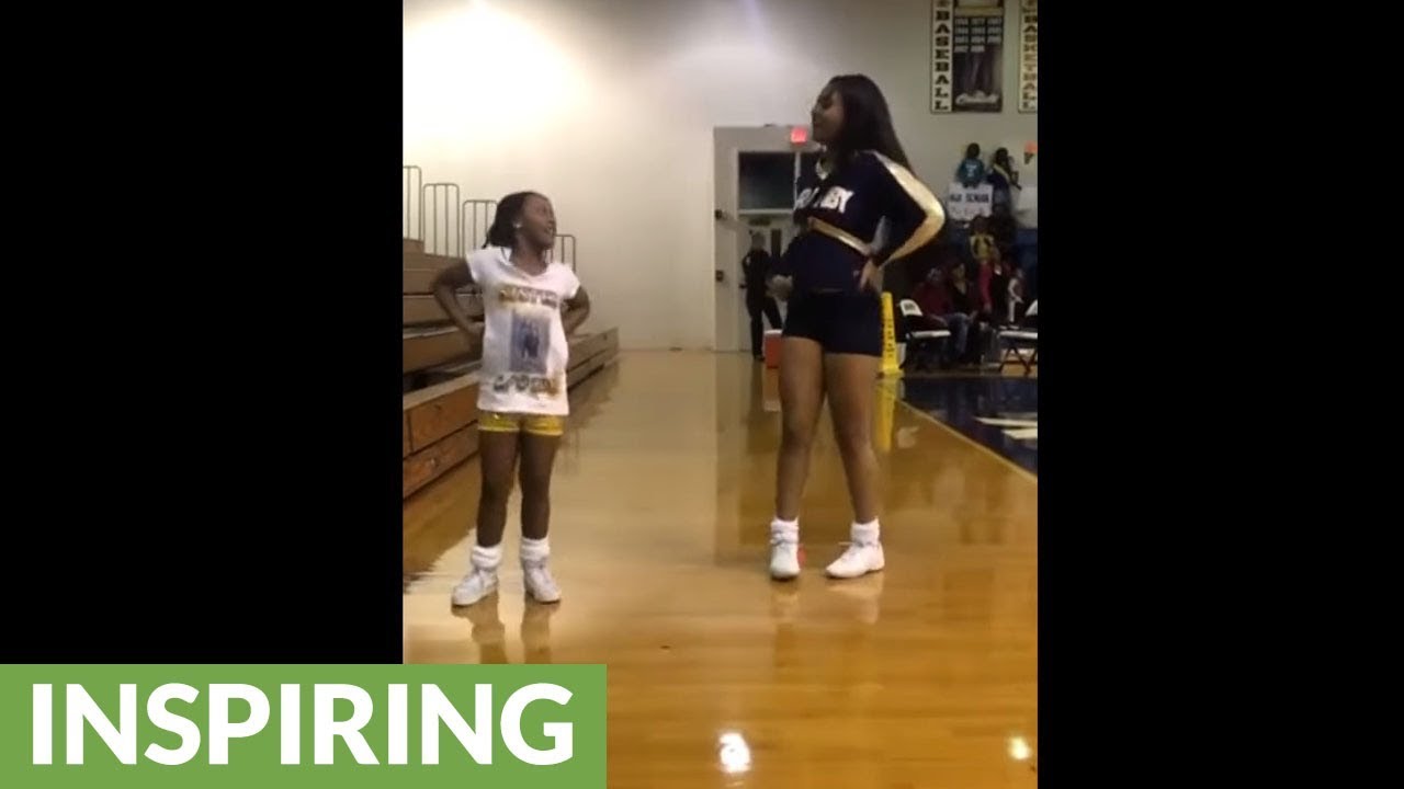 Little girl joins in on big sister's cheer solo