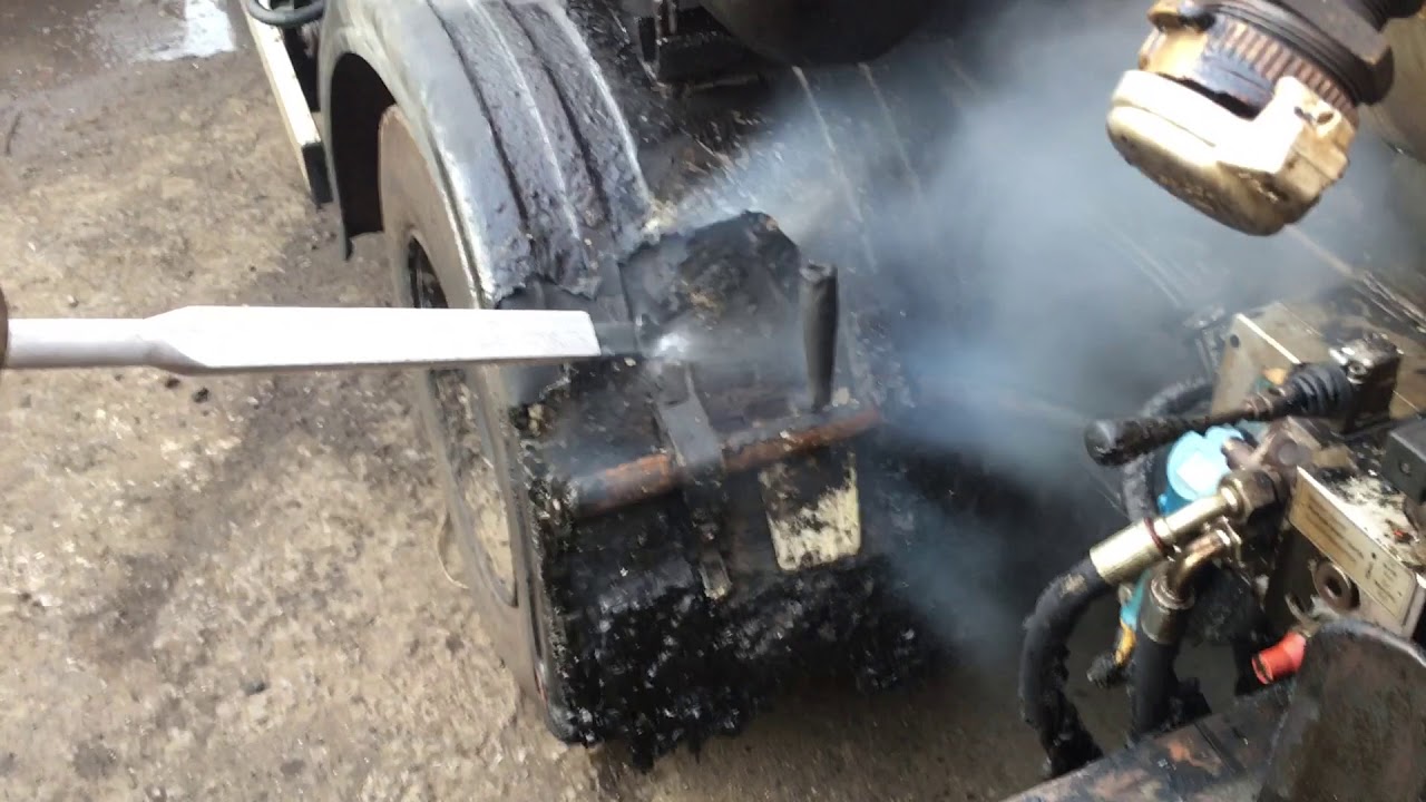 Cleaning parts of a bitumen sprayer using dry ice blasting