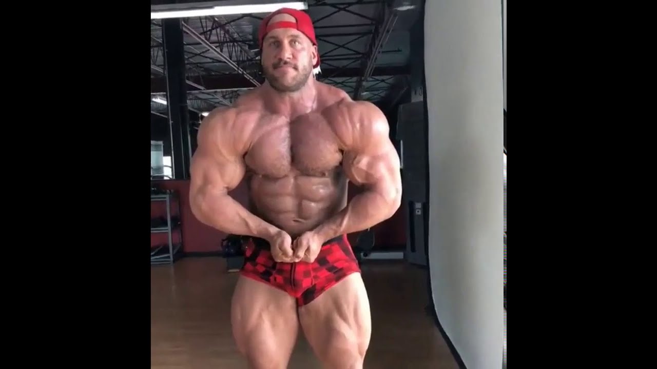 Massive bodybuilder posing and flexing at the gym