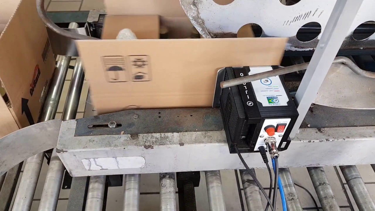 datador inkjet imprimindo em caixas de papel&atilde;o na sa&iacute;da de fechadora de caixas da 3M