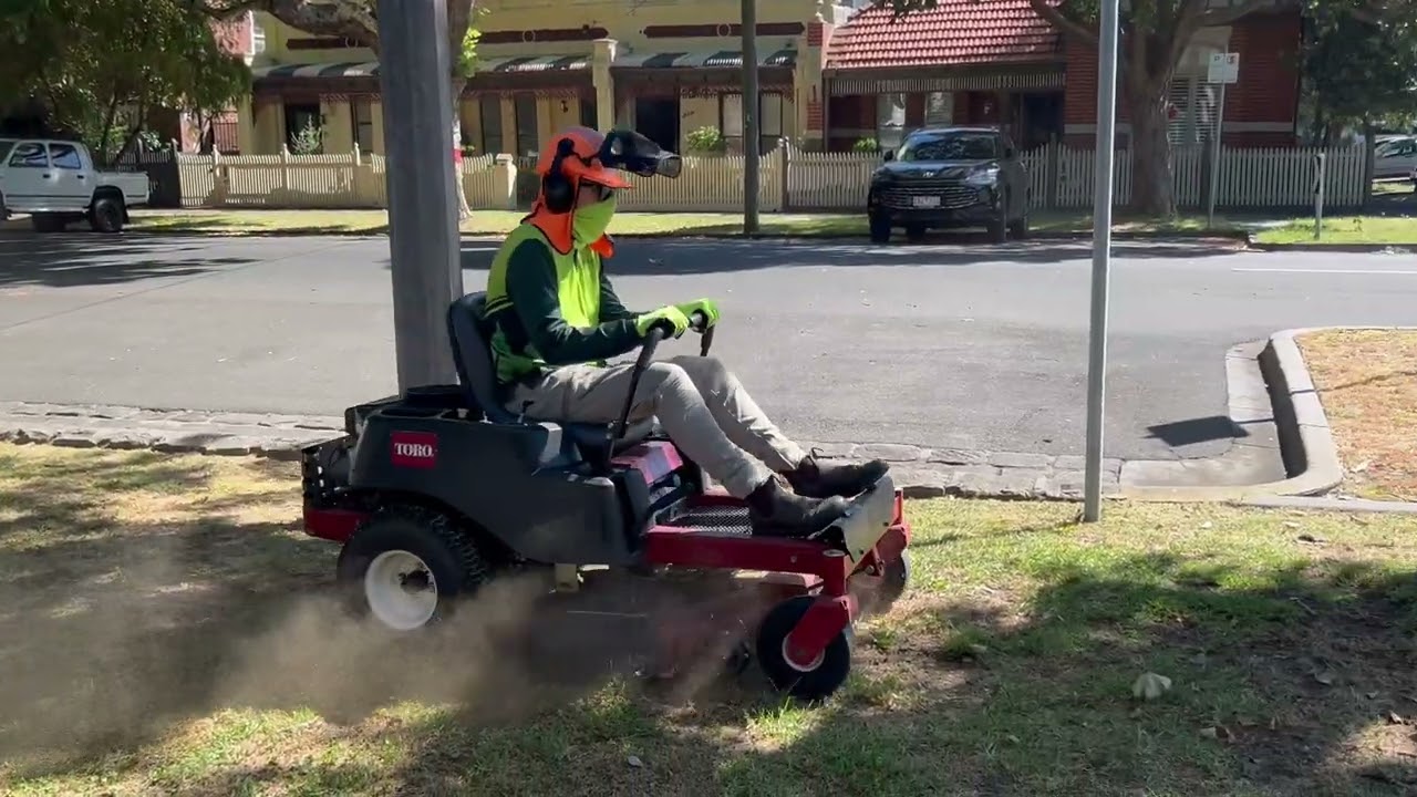 Ride on lawn mowing a large inner city nature strip 