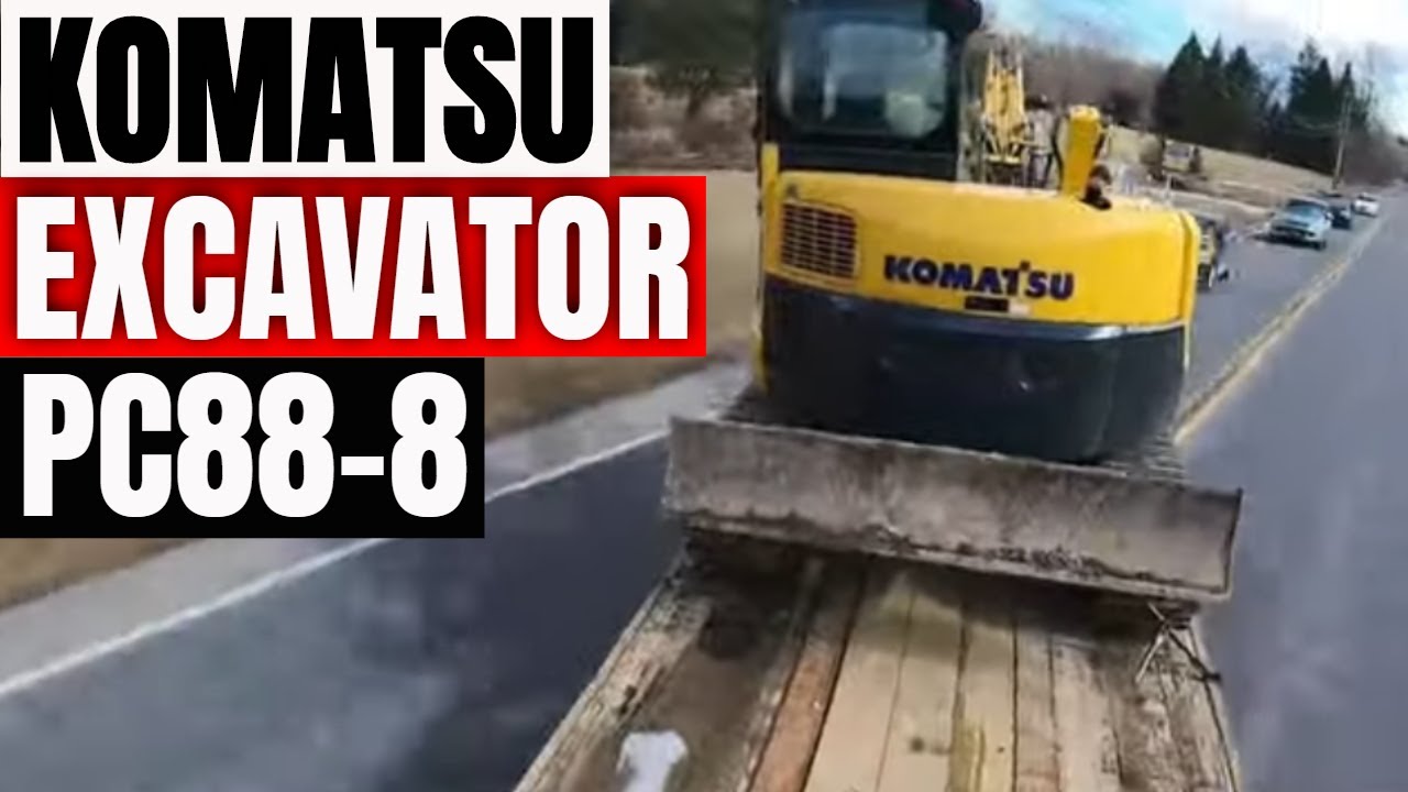Hauling a Komatsu excavator with dump truck and tag trailer