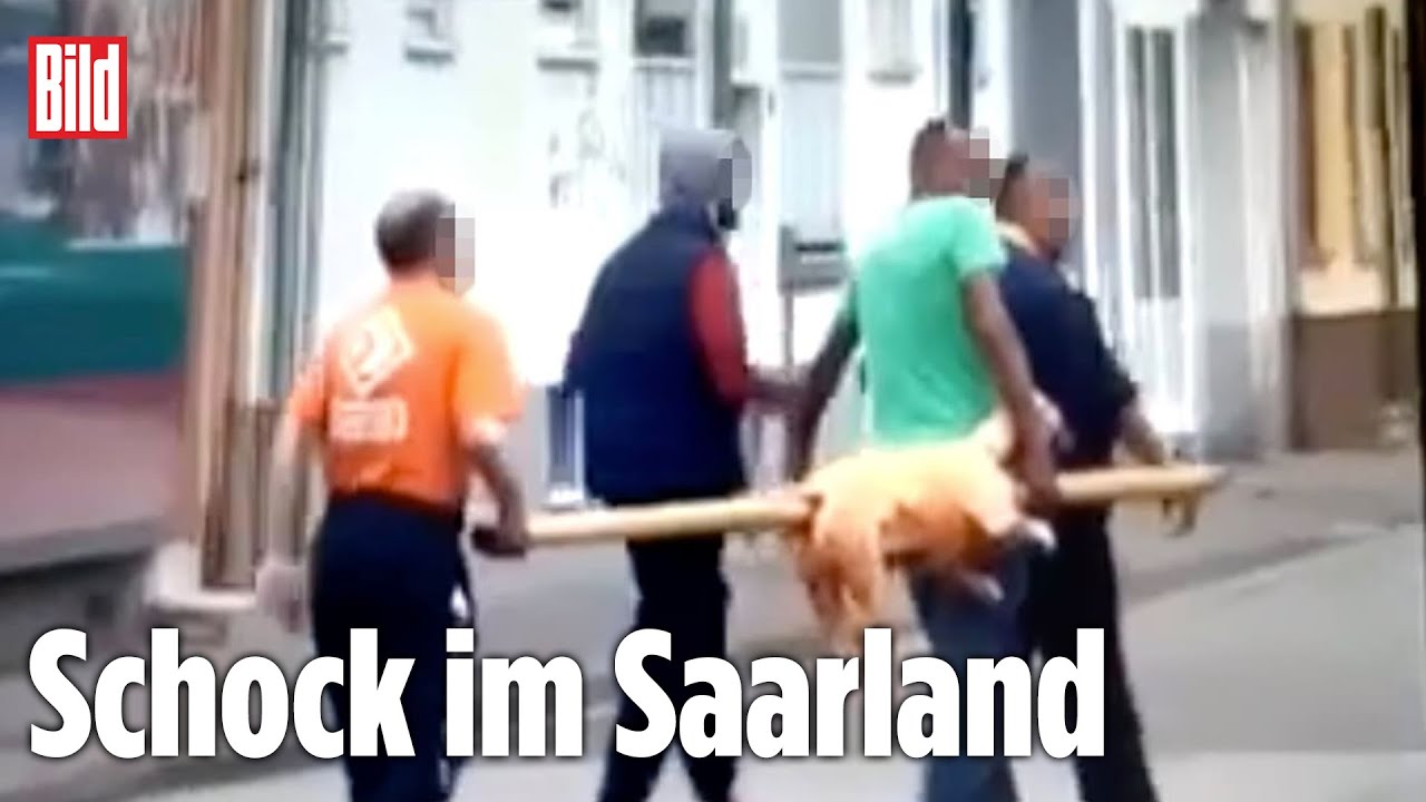Männer tragen aufgespießtes Tier durch Neunkirchen
