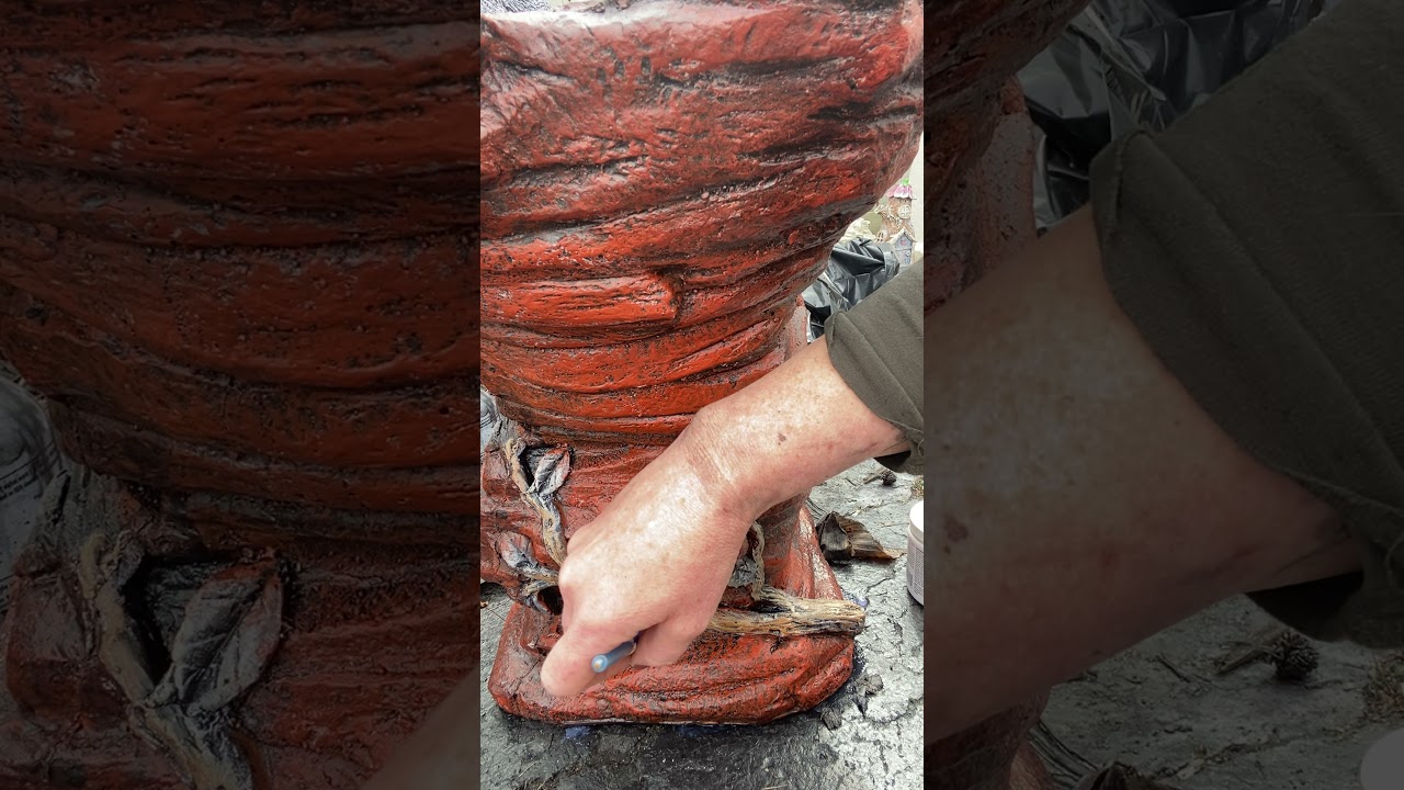 Painting branch and leaf detail on bear birdbath