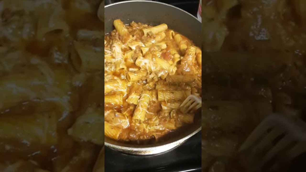 Spaghetti with sausage, parmesan shredded cheese.