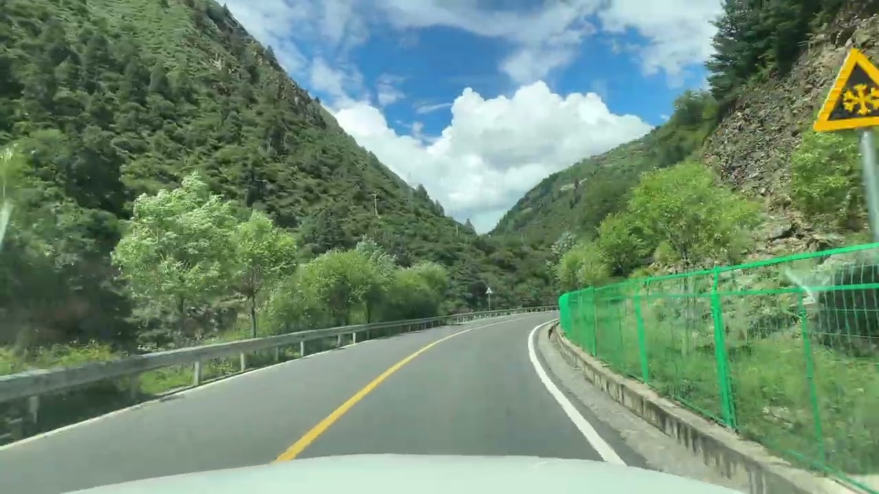 行在川西壤塘227國道：山水、民居與道路交織的和谐畫卷。