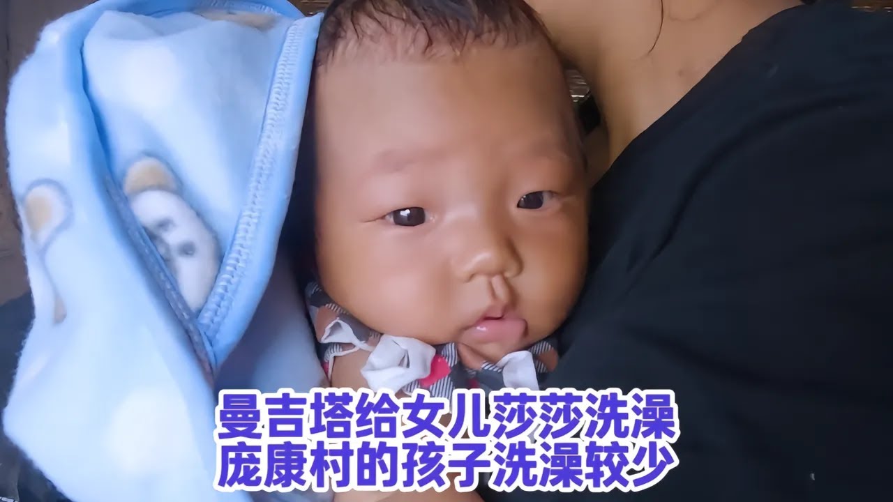 曼吉塔给女儿莎莎洗澡，庞康村的孩子洗澡洗得比较少，怕着凉感冒