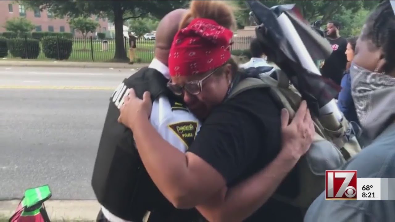 Woman hugs officer after Fayetteville police kneel in support of protests