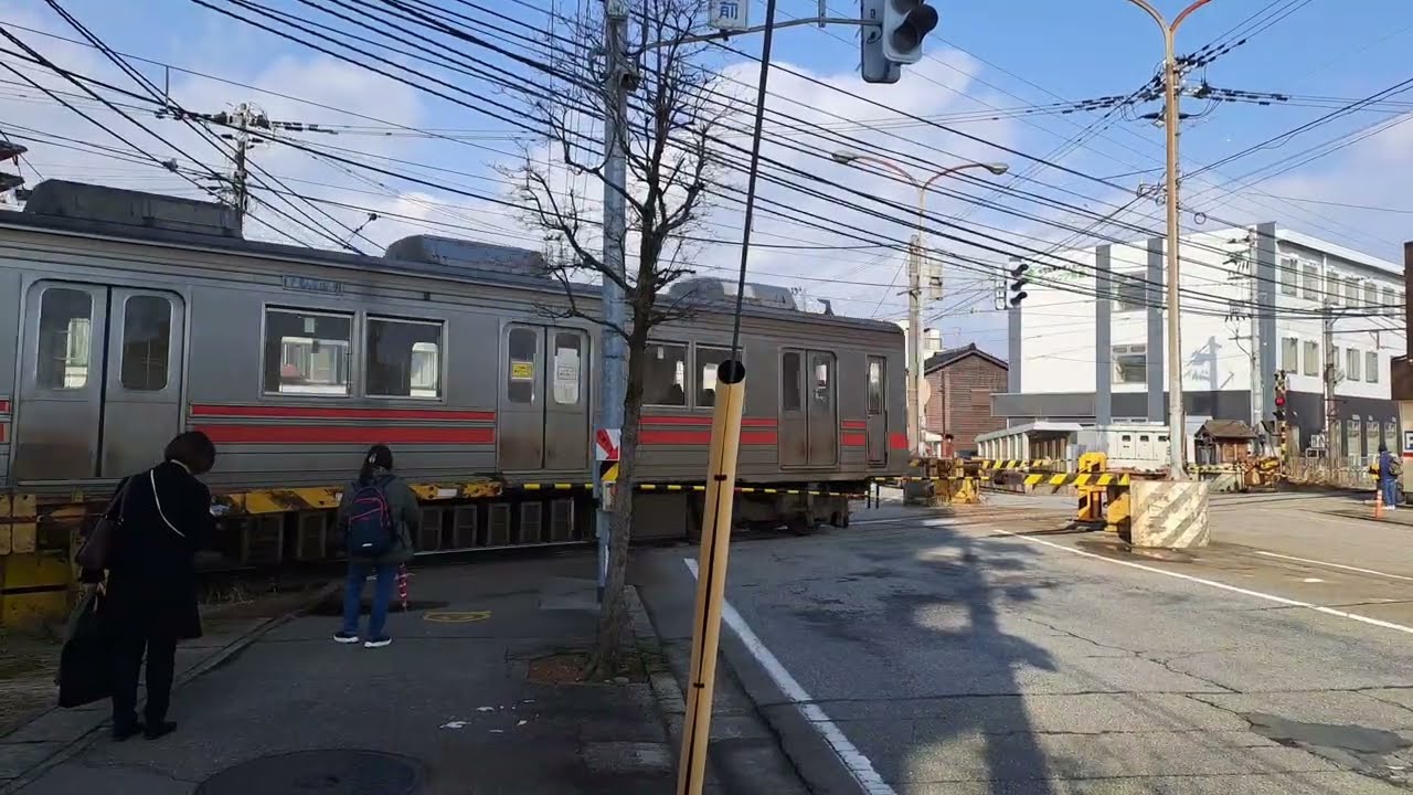 珍しい特殊型二段式の踏切（不二越上滝線の南富山駅前）両側の列車が次々に通った 16.1.2026.
