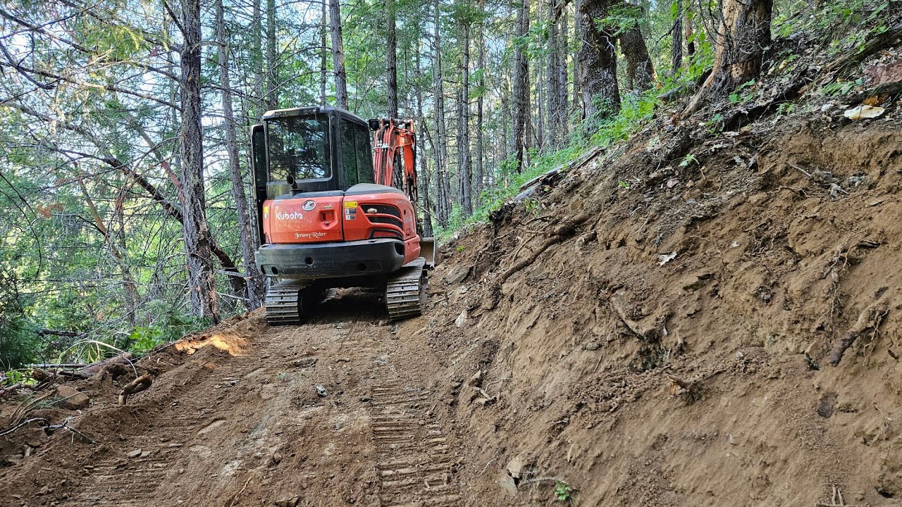 Sliding on rocks dodging treetops steep ATV road with the Kubota KX 040 4 excavator